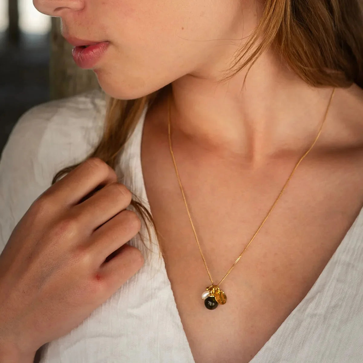 Goudkleurige Vinoos ketting Ode to Green Stilte gedragen door een model als stijlinspiratie