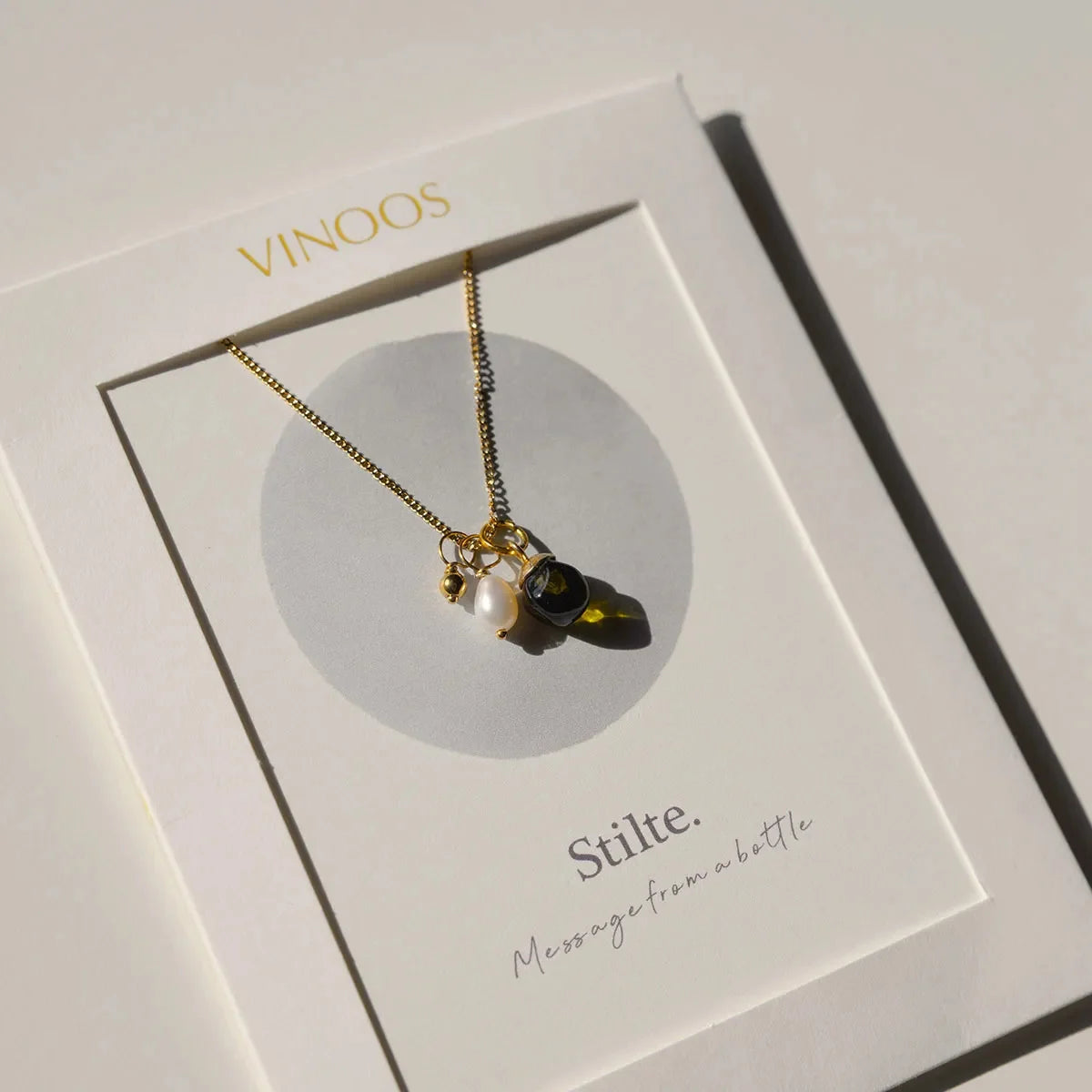 De goudkleurige Vinoos ketting gepresenteerd op het bijbehorende quote-kaartje met de tekst Ode to Green Stilte