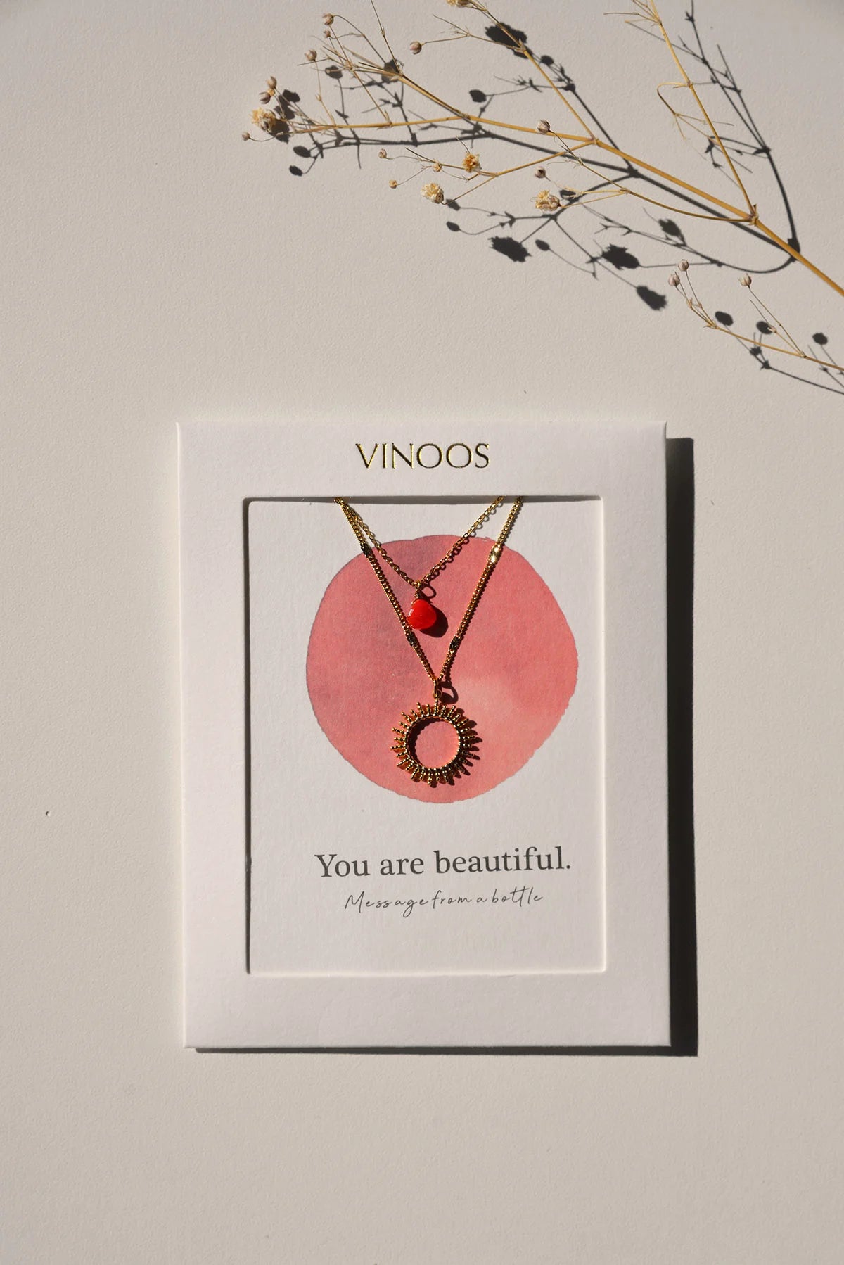 De goudkleurige Vinoos ketting gepresenteerd op het bijbehorende quote-kaartje met de tekst You are Beautiful
